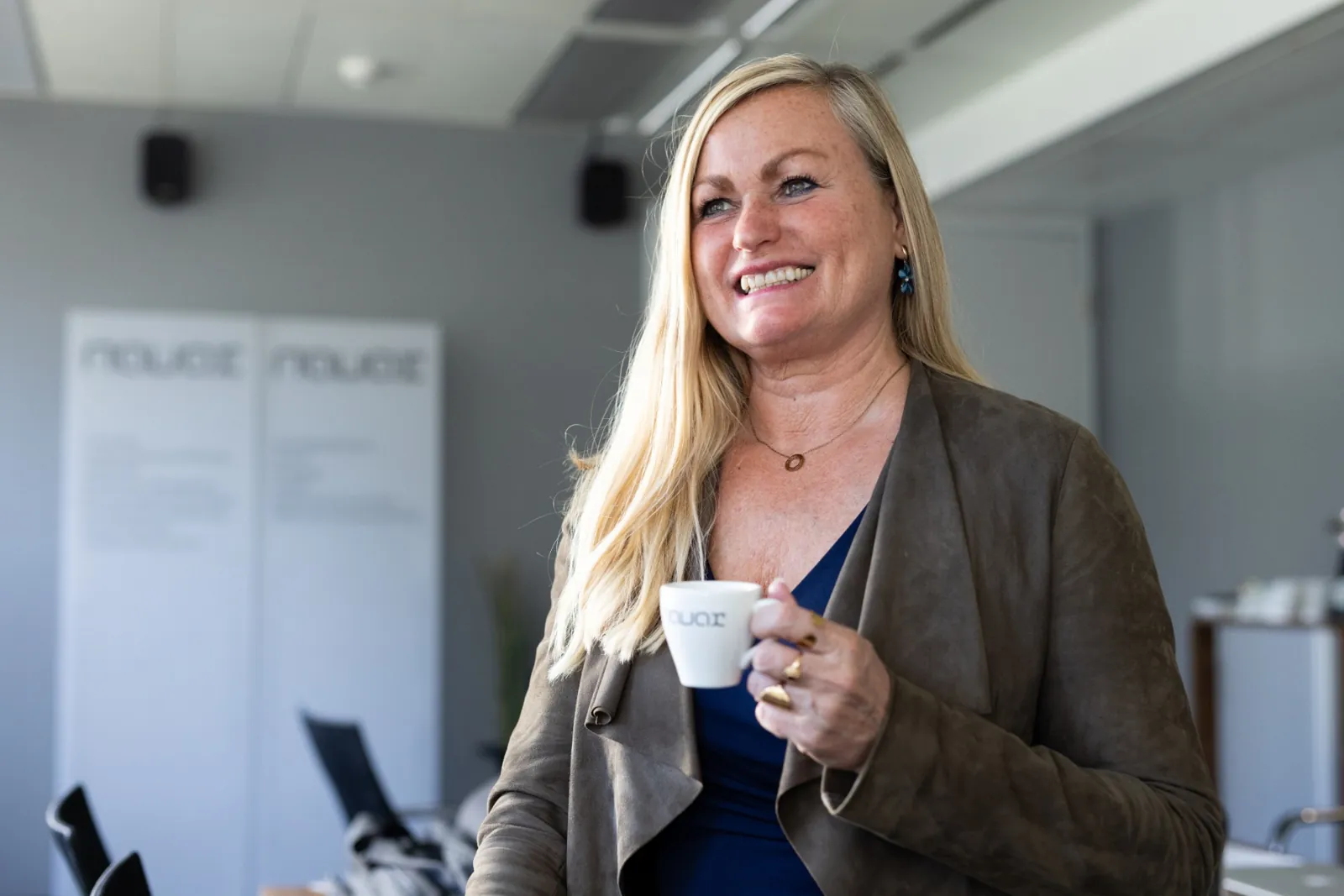 Nicole Plein, Ansprechperson in Pressefragen, mit einer NAVAX-Kaffeetasse