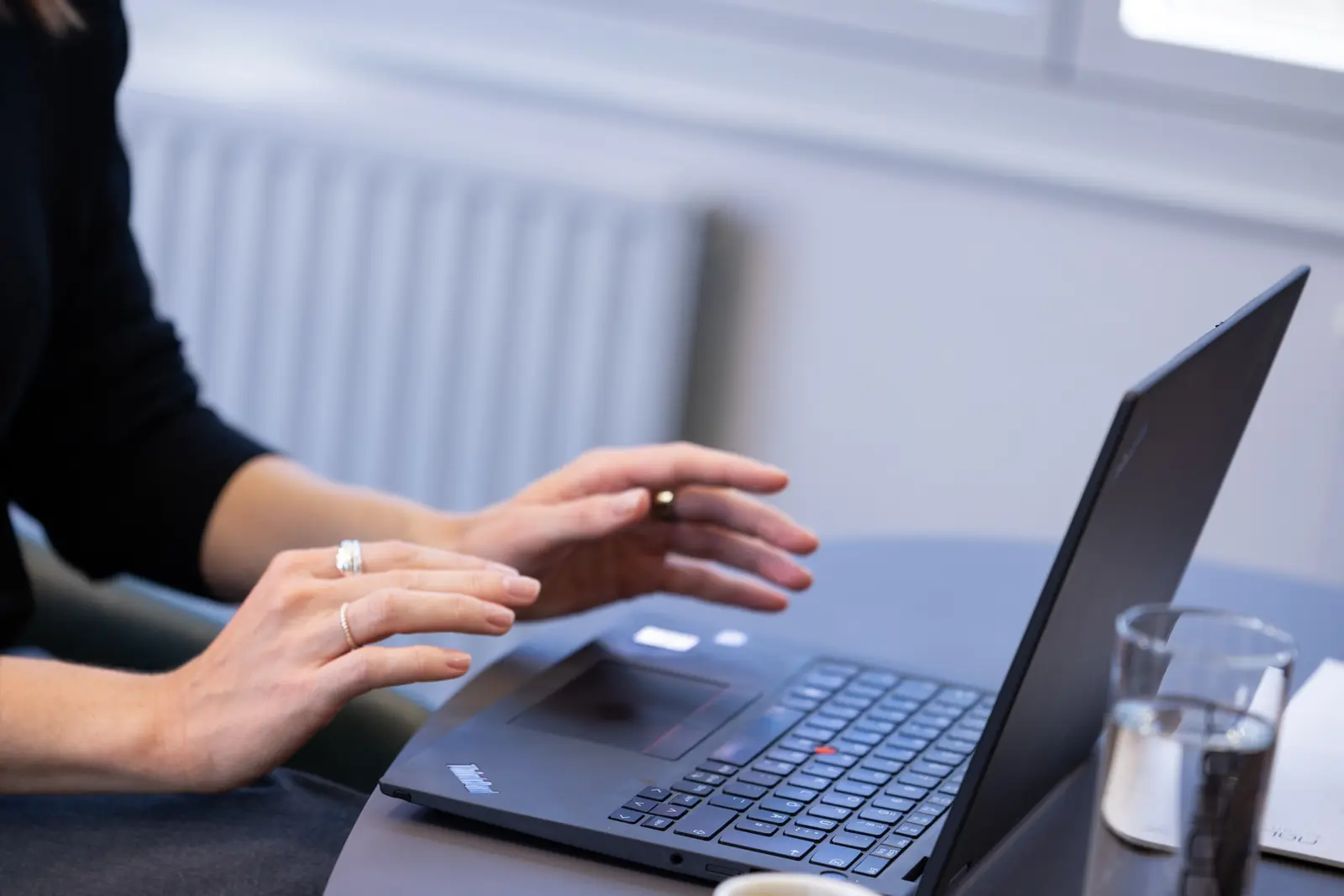 Hände auf der Tastatur eines aufgeklappten Laptops