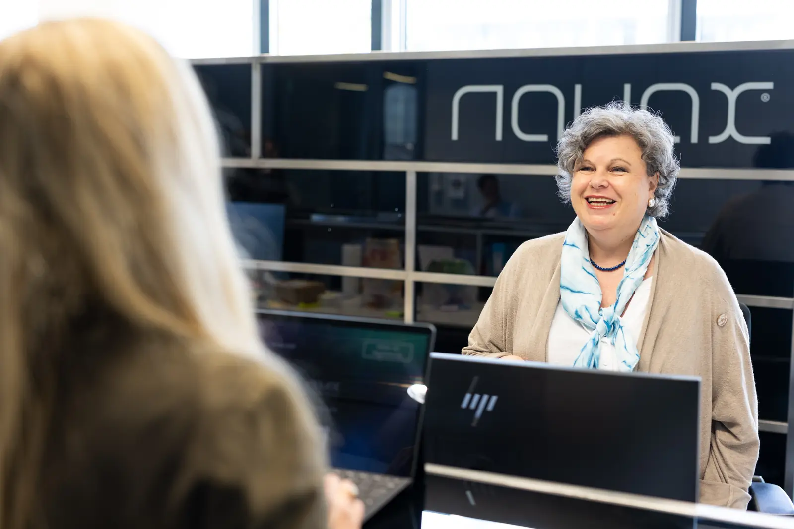 Eine Besucherin wird am Empfang von NAVAX begrüßt