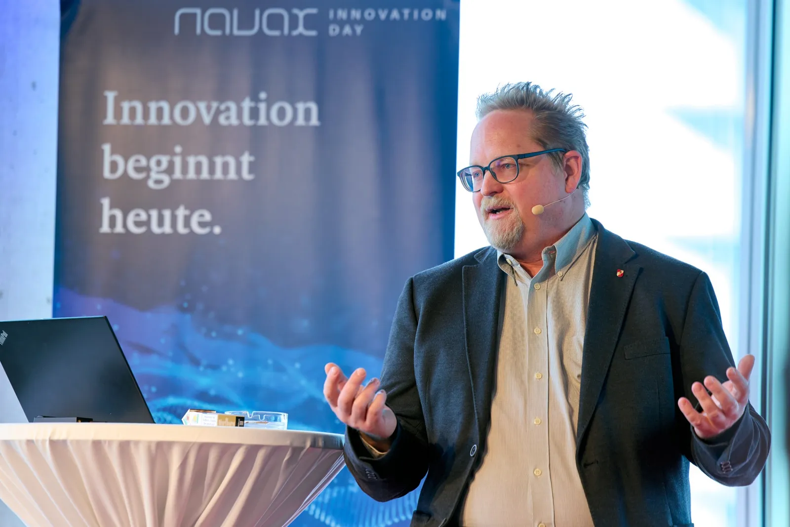 Talk in front of a banner reading “Innovation beginnt heute” (innovation starts today)