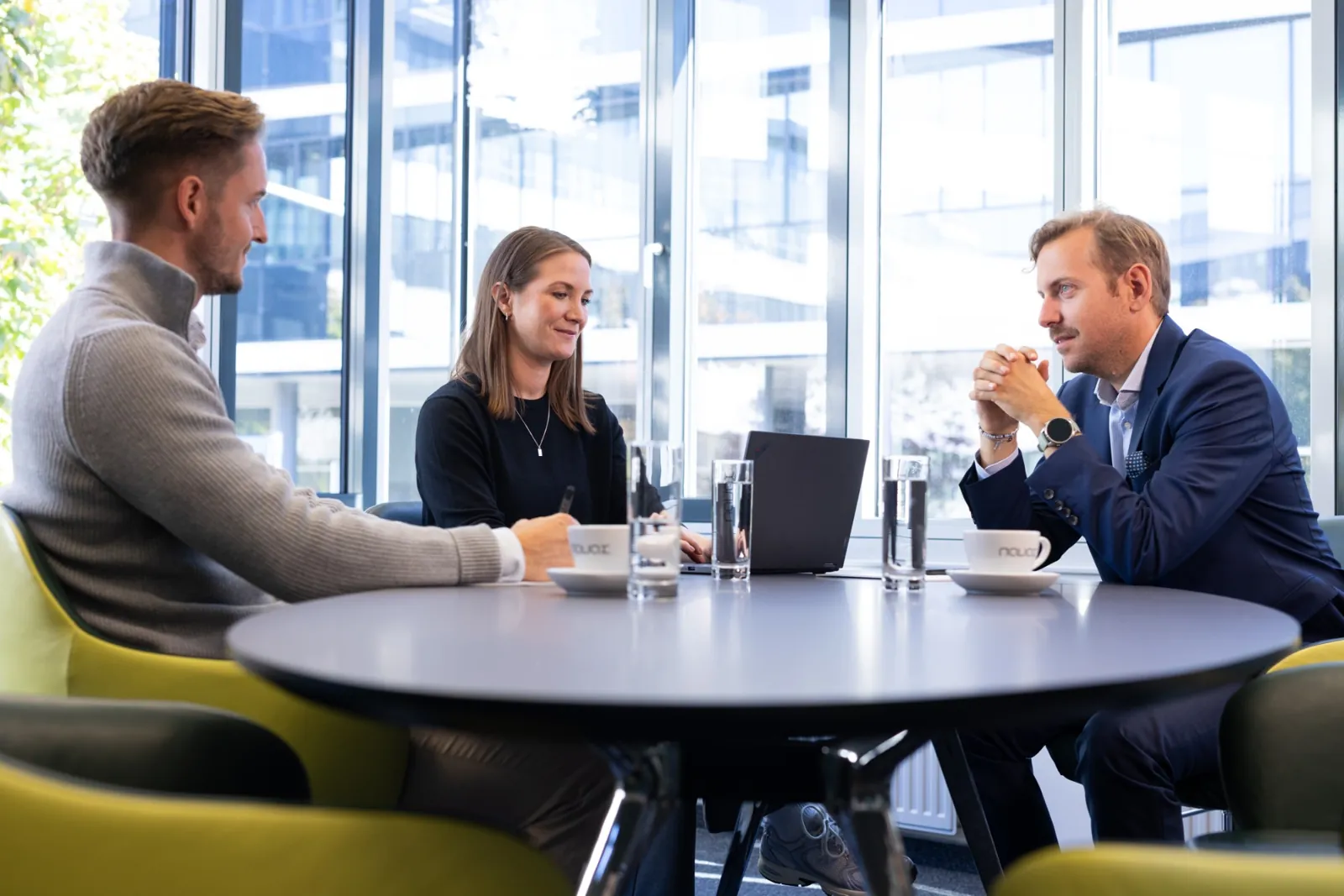Besprechung an einem runden Tisch mit Laptops