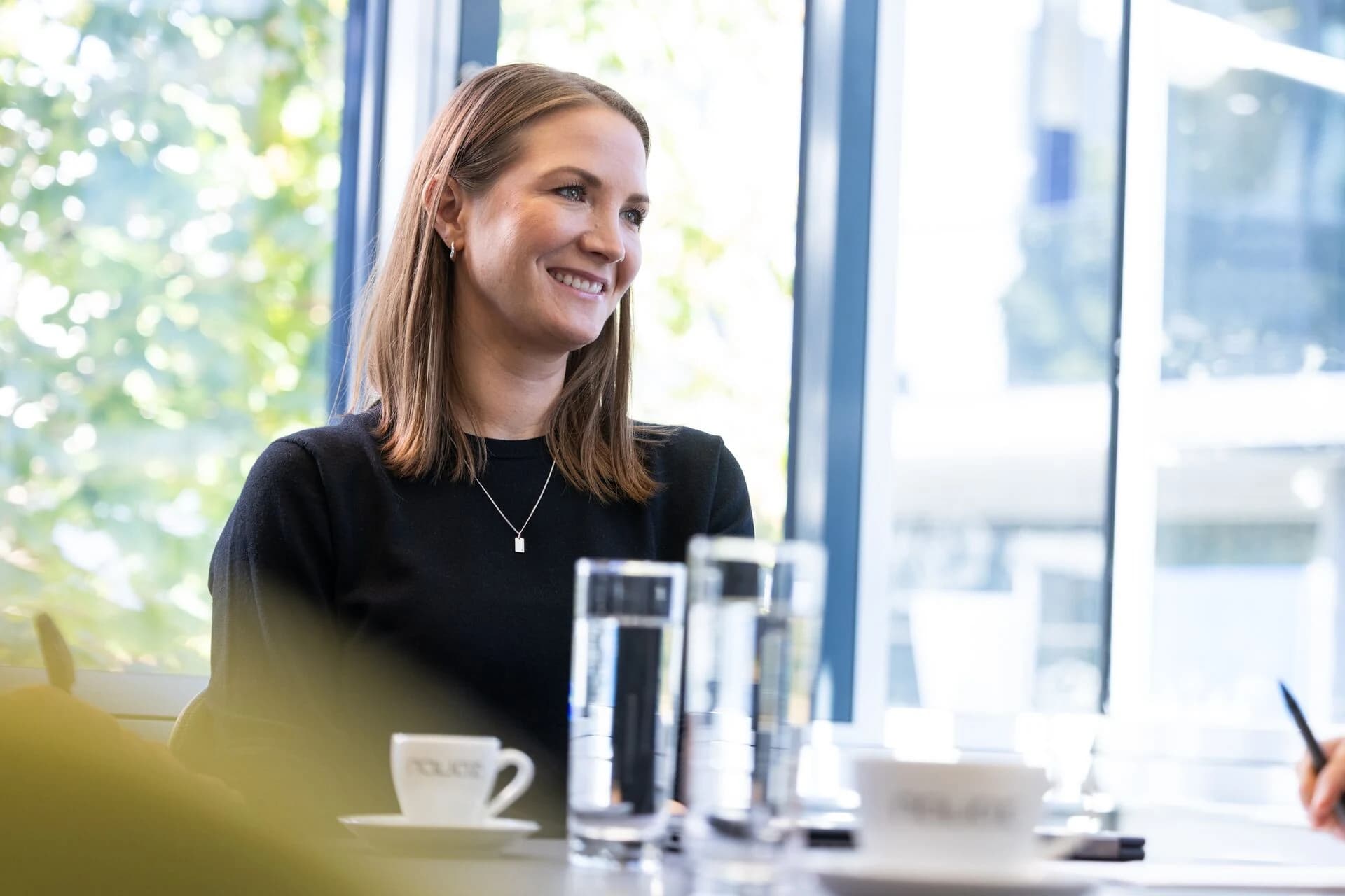 Eine Frau hört im Gespräch am Besprechungstisch zu