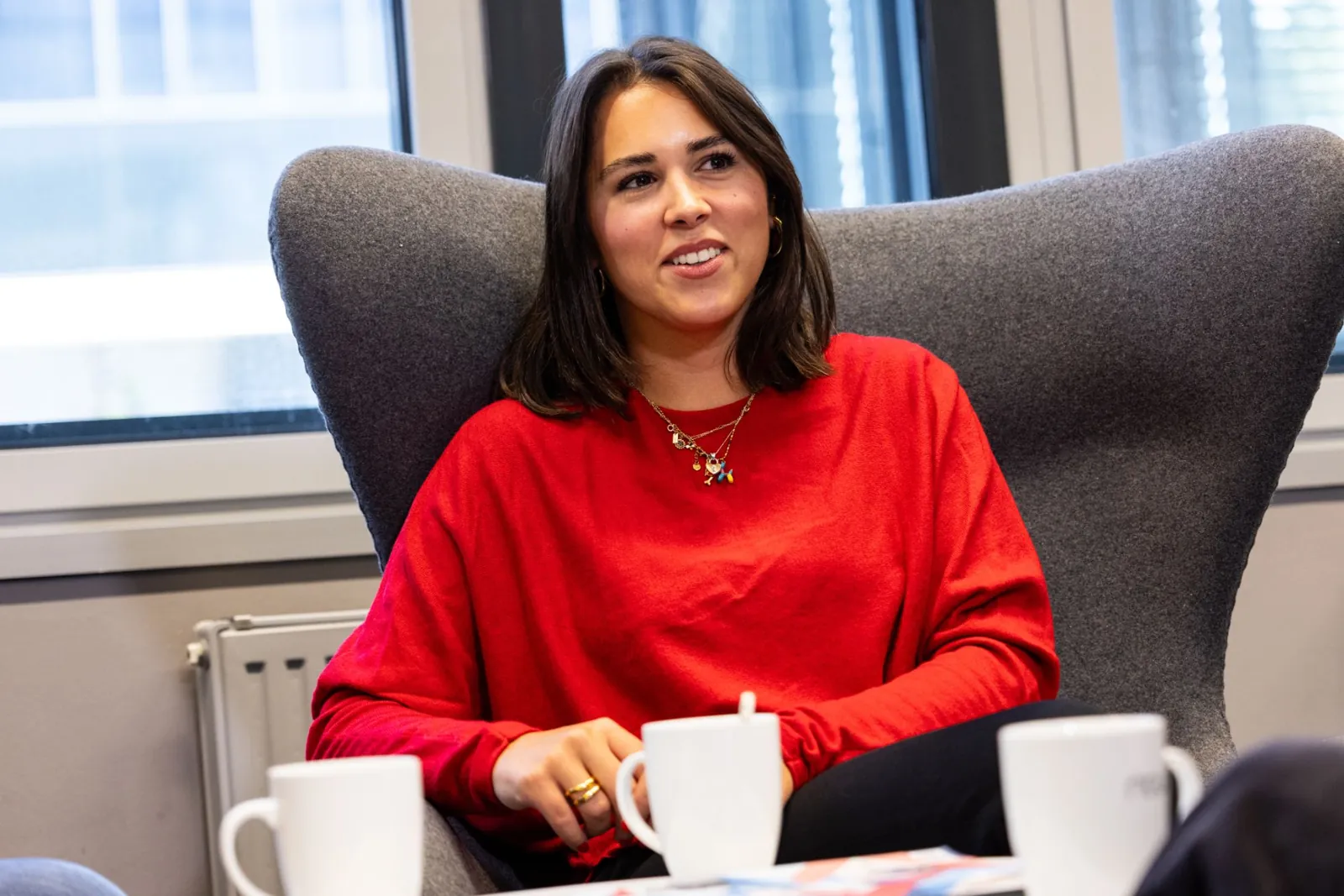 Employee in an armchair, talking with a cup of coffee