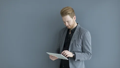 Mann liest Report auf Tablet