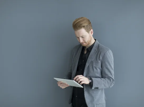 Mann liest Report auf Tablet