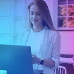 Frau sitzt vor Laptop und freut sich über Marketing Automation