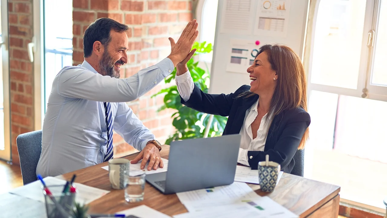 Frau und Mann schlagen im Büro ein